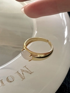 Macro detail of a 925 silver adjustable gold ring featuring a pink translucent gemstone