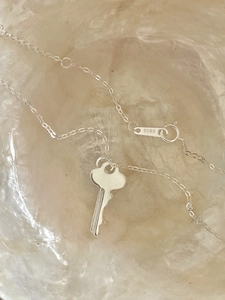 Macro shot of S925 sterling silver hallmark on minimalist key pendant necklace link