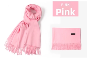 Detail of pink cashmere scarf with long fringe tassels and a premium soft woven texture