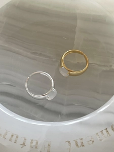 Detailed macro view of minimalist adjustable silver and gold rings with white moonstones