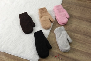 Cinque paia di guanti in maglia di lana in vari colori disposti in piano