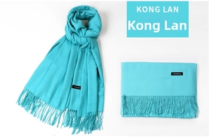 Detail of teal cashmere scarf showing tassel edges and folded textures for warmth