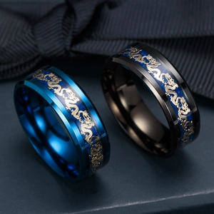 Close-up of blue and black stainless steel rings with gold dragon pattern engravings