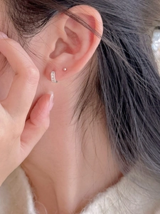 Close-up of 925 sterling silver huggie hoop and ball stud earring with zircon inlay