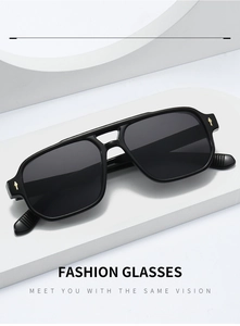 Detailed macro view of black double-bridge sunglasses with gold arrow-shaped metal accents