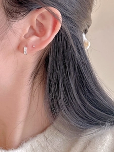 Close-up of minimalist 925 sterling silver hoop earrings with zircon stones on ear