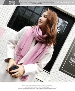 Pink long cashmere shawl scarf with tassels worn over a white wool coat