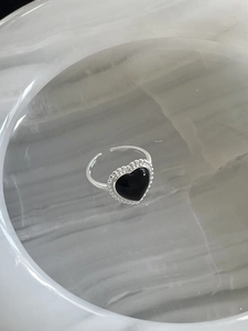 Détail d'une bague en argent S925 avec cœur en agate noire et bordure perlée chic