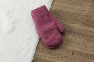 Muffole in maglia rosa in lana di coniglio su pelliccia bianca e legno con fiori secchi