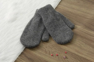 Moffole in lana grigia su legno con pelliccia bianca e fiori secchi rossi in primo piano