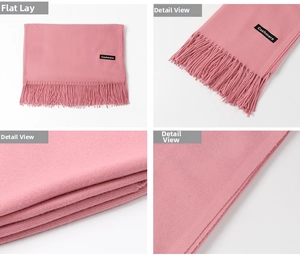 Detail view of pink cashmere scarf with fringe tassels and soft textile texture