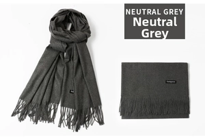 Macro detail of neutral grey cashmere scarf showing soft texture and tassel fringe