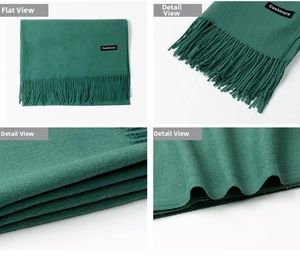 Detail view of emerald green cashmere scarf showing tassels and fabric material labels