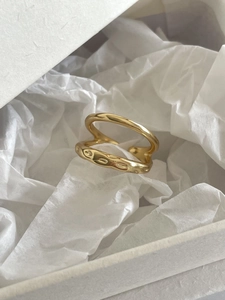 Detail of a golden double-layered ring with wave texture and adjustable open design