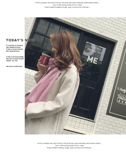 Pink cashmere scarf with tassels paired with a white coat in an autumn street setting