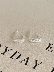 Close-up of S925 sterling silver C-shaped earrings with micro-pave white zircon stones