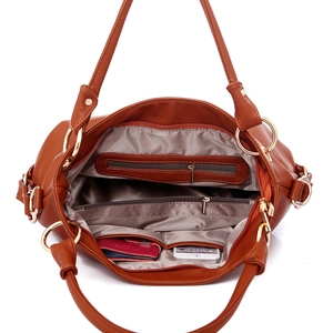 Brown faux leather handbag with tassel detail showing spacious interior compartments