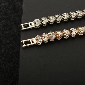 Detail of silver and gold heart link bracelets with sparkling crystals and fold-over clasps