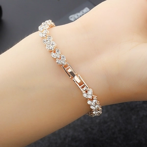 Close-up of rose gold heart-link bracelet with sparkling crystals on a wrist