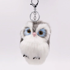 Close-up of white and grey plush owl keychain with fluffy texture and metal chain
