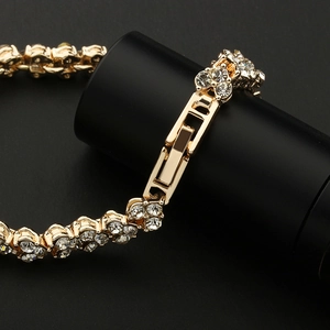 Close-up of gold-plated crystal bracelet with metal folding clasp on black background
