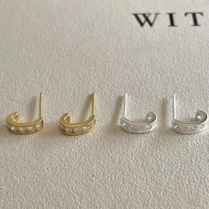 U-shaped stud earrings in gold and silver with cubic zirconia in minimalist style