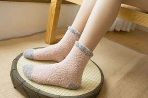 Gros plan de chaussettes en polaire corail rose et gris à texture épaisse et douce