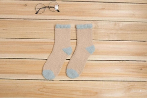 Gros plan de chaussettes en polaire corail épaisses kaki et bleu sur parquet