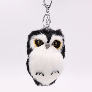 Detail of owl plush keychain featuring soft faux fur texture and metal lobster clasp