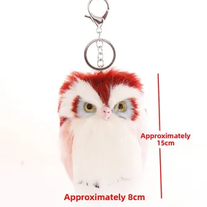 Detail showing red and white plush owl keychain with dimensions approx. 15cm x 8cm