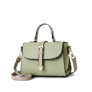 Gros plan détaillé du sac contrasté vert clair et beige avec texture en cuir grainé litchi