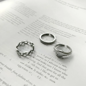 Three-piece set of S925 sterling silver vintage rings placed on an open book background