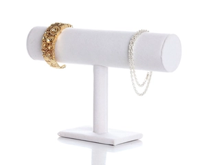 Detail view of a white velvet T-bar jewelry stand displaying gold and silver bracelets