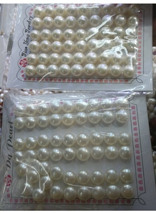 Close-up of white natural freshwater bread pearls in transparent packaging bags