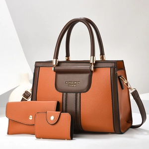 Three-piece leather handbag set in orange and brown contrast with pebble texture