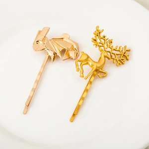 Golden geometric deer and elk hair clips set on a minimalist white plate display