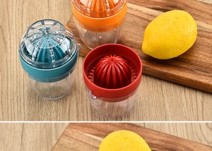 Three colorful citrus juicers in cyan, red, and orange on a wooden kitchen table