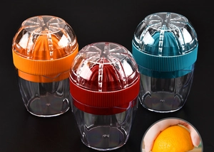 Three colorful manual citrus juicers in orange, red, and blue with transparent cups