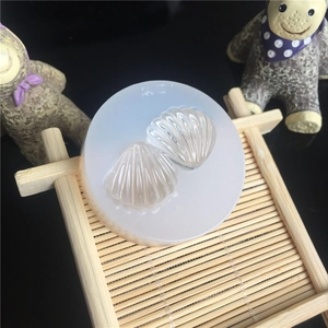 Detail of round translucent silicone mold with shell patterns on a decorative bamboo mat