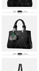 Detail of black faux leather handbag featuring white geometric stitching and pompom charm