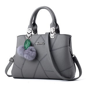 Elegant grey faux leather tote bag with embroidery stitching and fuzzy ball pendant charm