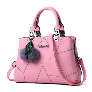 Pink lychee leather handbag for women with geometric stitching and fur ball charm