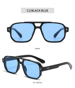 Detail of square pilot sunglasses in black frames with blue lenses and gold rivets