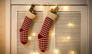 Gros plan de chaussettes de Noël en tricot rouge à pois blancs suspendues aux stores