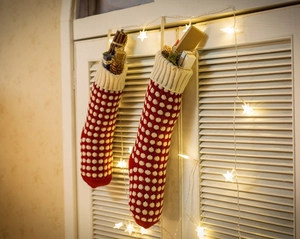 Détail de chaussettes de Noël en tricot rouge à pois blancs avec petits cadeaux