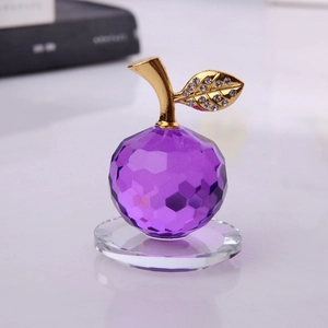 Mela in cristallo viola sfaccettato con gambo dorato e foglia brillante sulla base