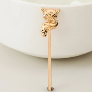 Golden geometric fox alloy hair clip on a white ceramic bowl in a clean setting