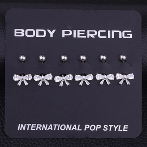 Détail de 6 piercings de nombril en acier inoxydable en forme de nœud avec zircon brillant