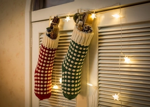 Détail de chaussettes de Noël tricotées à pois avec garnitures festives et cadeaux