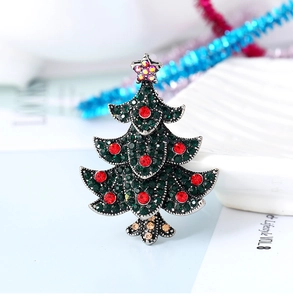 Close-up of vintage Christmas tree brooch with emerald green and red sparkling rhinestones